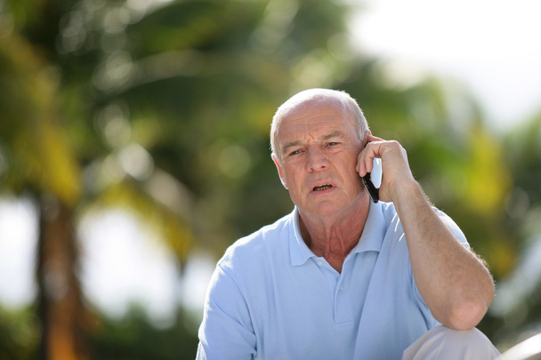 Elderly man talking on his mobile phone - Fotó, kép