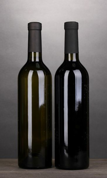 Bottles of great wine on wooden table on grey background - Zdjęcie, obraz