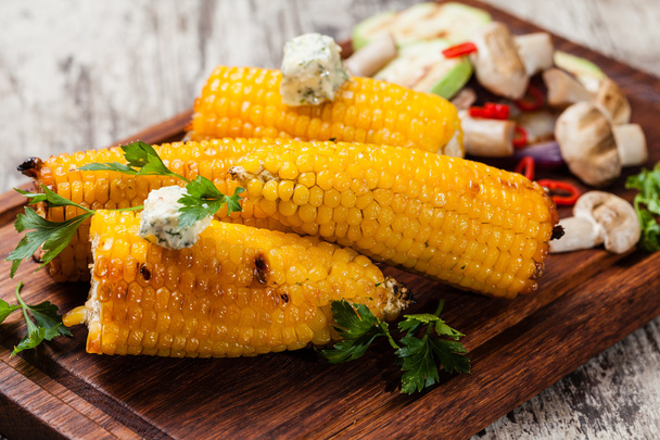 Grilled corn cobs on wooden plate - Foto, afbeelding