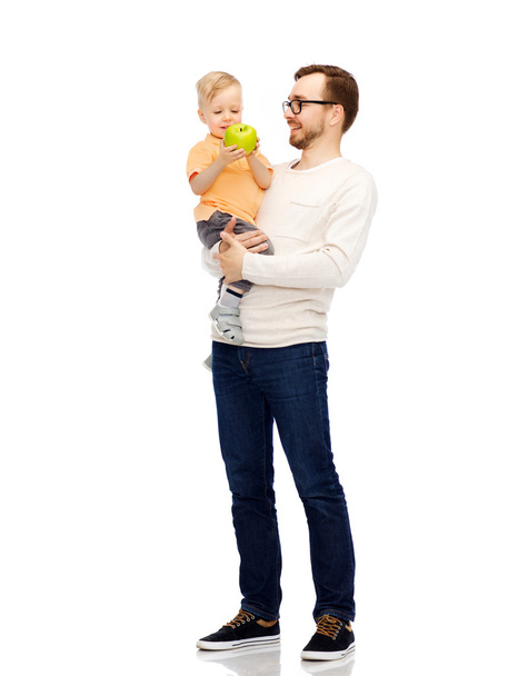 gelukkige vader en kleine zoon met Apple - Foto, afbeelding