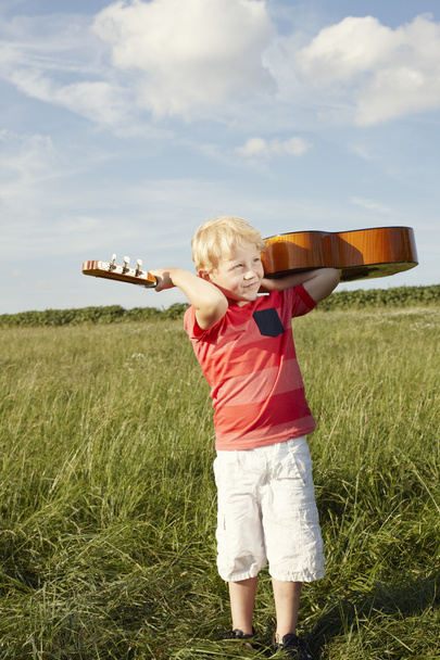 Niño pequeño con guitarra de madera
 - Foto, Imagen