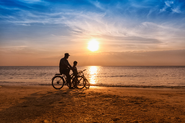Ποδηλάτης οικογένειας σιλουέτα πατέρα και γιου στην παραλία στο ήλιο r - Φωτογραφία, εικόνα
