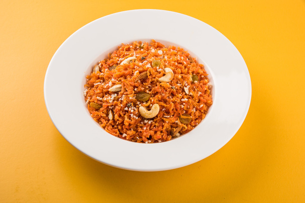 tasty gajar halwa or gajar ka halwa made up or fresh carrot, sugar and milk. decorated with almond or badam, cashewnuts and pistachios, favourite north indian dessert usually served in weddings - 写真・画像
