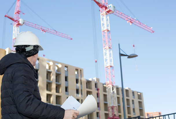 An engineer on a construction site with cranes - Fotoğraf, Görsel