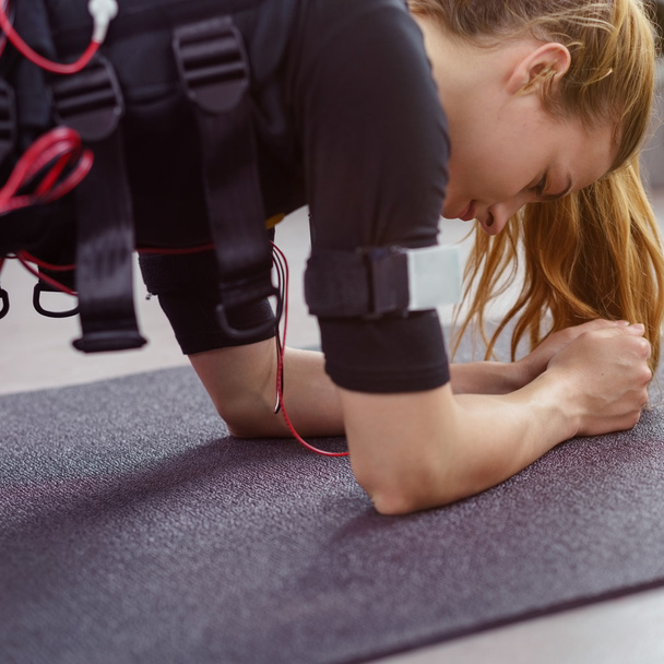 Athletic woman in biometric vest in plank drill - Foto, Bild