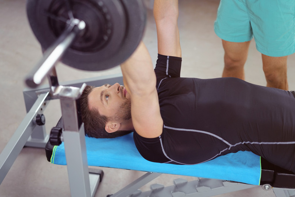 Healthy young male bodybuilder lifting weights - Valokuva, kuva