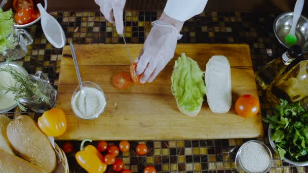 Σεφ κόβει και βάζει ντομάτες για το σάντουιτς - Πλάνα, βίντεο