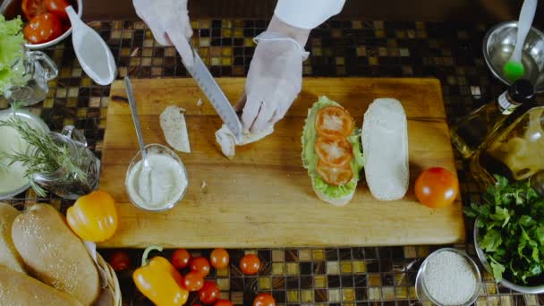 Le chef coupe le poulet et le met sur un sandwich
 - Séquence, vidéo