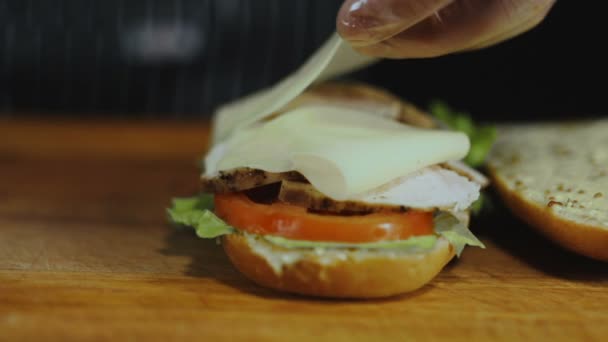 シェフは、サンドイッチのチーズのスライスを追加します - 映像、動画