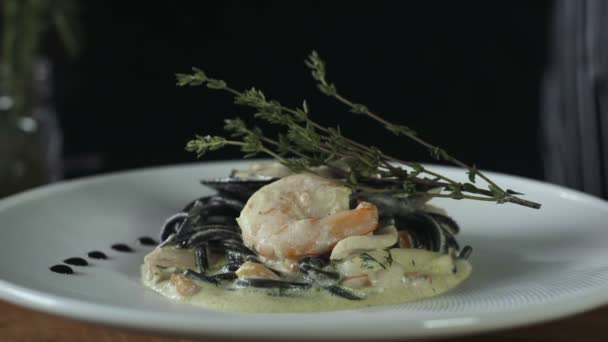 Μαύρο Σπαγγέτι με γαρίδες σε πλήρη άσπρο πιάτο - Πλάνα, βίντεο