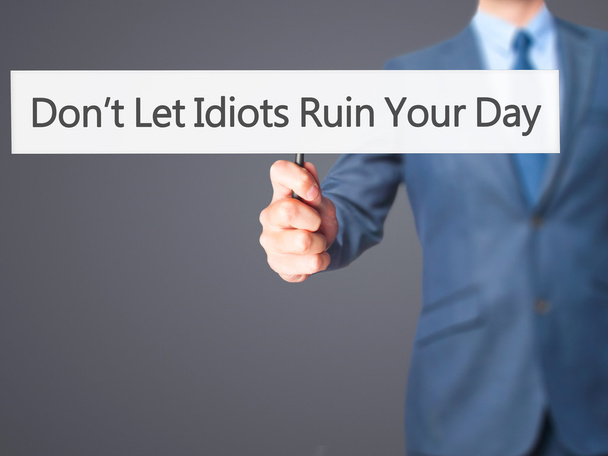 Lassen Sie sich den Tag nicht von Idioten verderben - Geschäftsmann hält Schild in der Hand - Foto, Bild