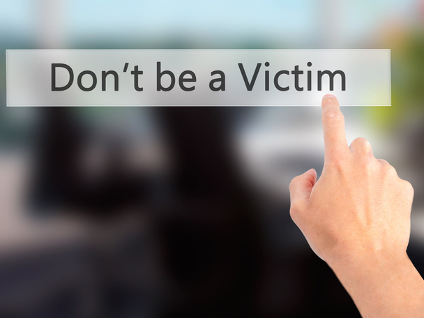 Να μην είστε θύμα - χέρι πιέζοντας ένα κουμπί σε θολή φόντο - Φωτογραφία, εικόνα