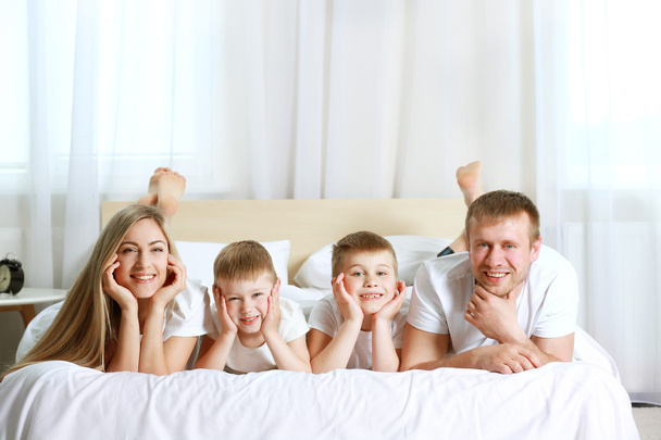 Happy lovely family on bed - 写真・画像
