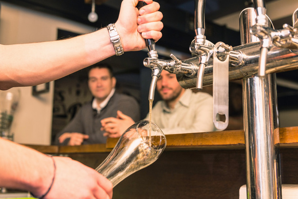 Barkeeper gießt Bier aus dem Zapfhahn  - Foto, Bild