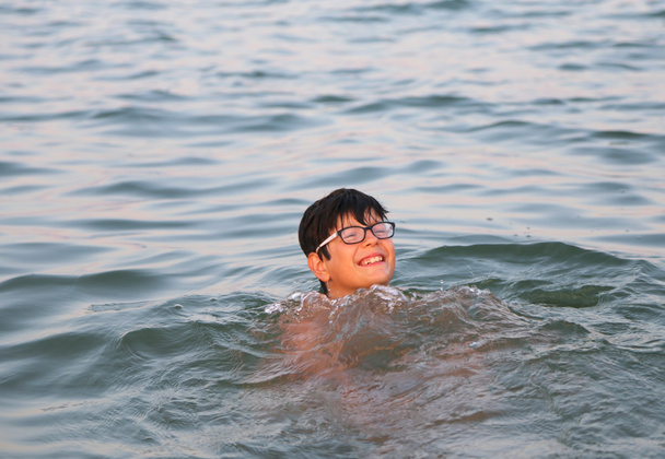 niño con gafas juega en agua de mar durante las vacaciones de verano
 - Foto, imagen