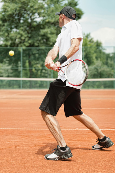 Jogador de tênis batendo Backhand
 - Foto, Imagem