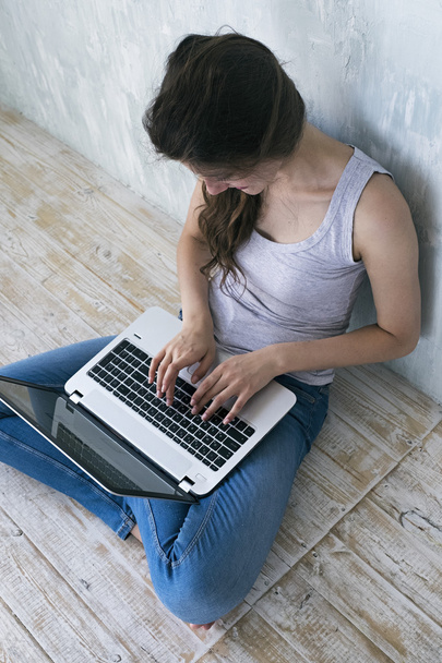 Brunette girl typing on laptop keyboard - Foto, afbeelding