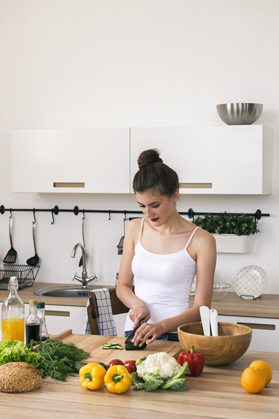 Calm beautiful housewife cutting vegetables in kitchen - Foto, Bild