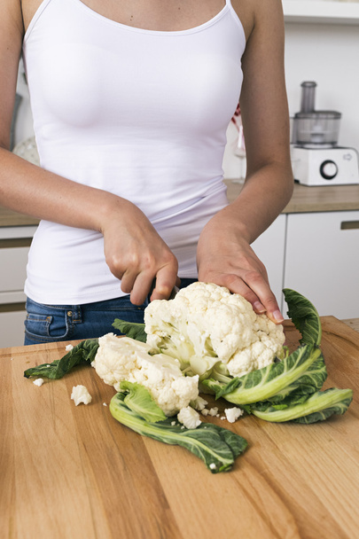 close-up of woman cutting cauliflower - Foto, afbeelding