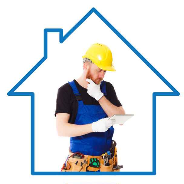 Людина будівельник синім рівномірного з планшета - Фото, зображення