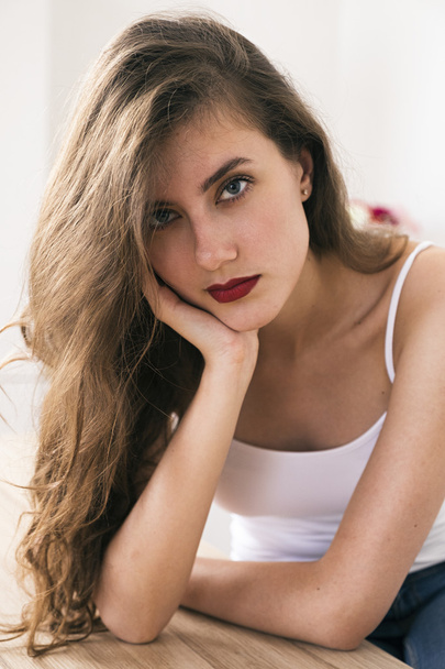 Attractive young brunette with blue eyes and red lips looking at camera - Foto, afbeelding