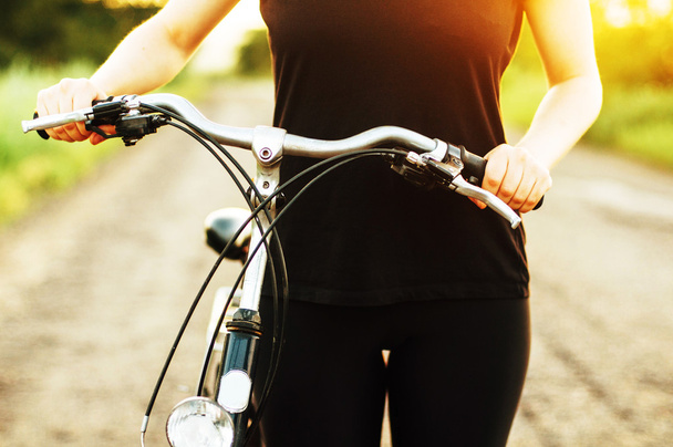 Detail of a bicycle. Woman riding her bicycle. Bicycle  on road  - Foto, imagen