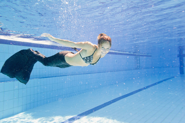 woman in mermaid costume swimming in pool - Photo, Image