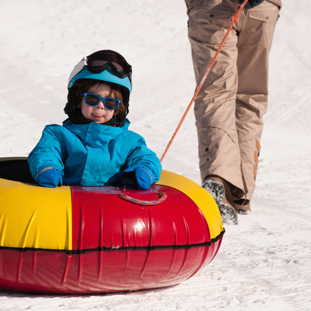 chłopiec cieszyć jazdą w snow tube - Zdjęcie, obraz