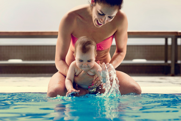 Mère avec son fils assis sur le bord de la piscine
 - Photo, image