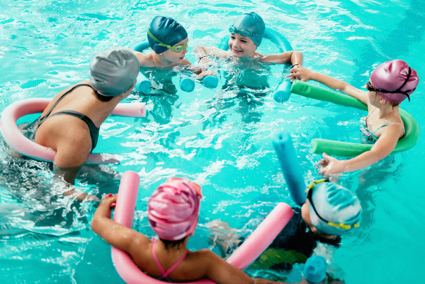 children having fun in swimming school - Foto, imagen