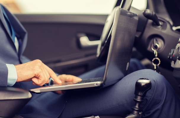young man with laptop driving car - Foto, Imagem