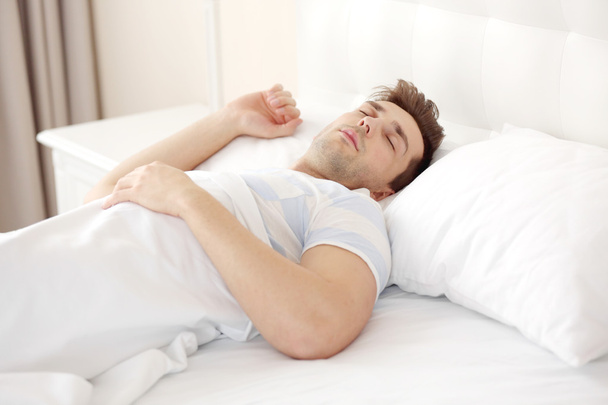 Young man sleeping on bed - Φωτογραφία, εικόνα