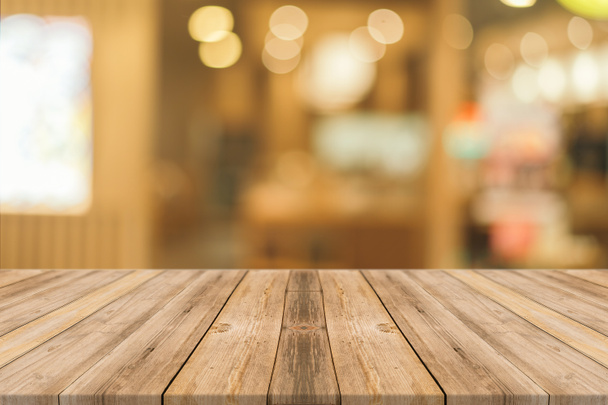 Houten bord lege tafel voor wazige achtergrond. Perspectief bruin hout over vervaging in coffeeshop - kan worden gebruikt voor het weergeven of monteren van uw producten.Mock up voor weergave van het product. - Foto, afbeelding
