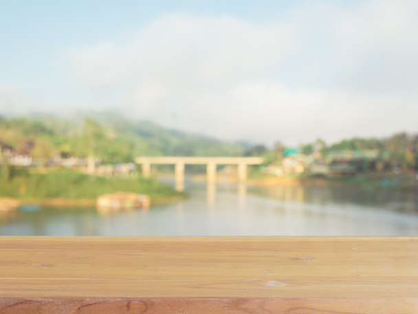 Placa de madeira mesa vazia na frente do fundo borrado. Perspectiva de madeira marrom sobre ponte de madeira borrão - pode ser usado simular para exibir ou montar seus produtos. Época. vintage filtrado
. - Foto, Imagem