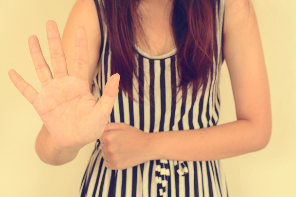 Jeune femme montrant son déni avec NON sur sa main, image filtrée vintage
. - Photo, image