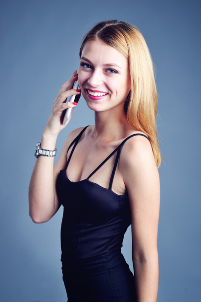 Young beautiful woman writes an SMS to your mobile phone - Fotografie, Obrázek