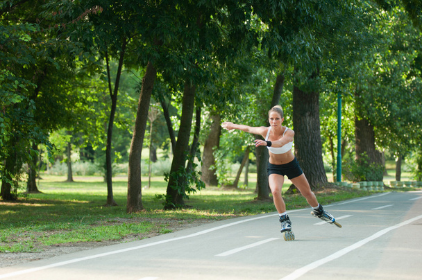 公園を通って女性ローラー_スケート - 写真・画像