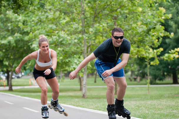 couple roller skating through park - Photo, Image