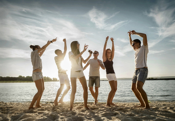 De grappige dans vrienden op het strand  - Foto, afbeelding