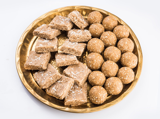 σουσάμι laddu ή tulgul ή til Γκιουλ laddu ή ladu στην πλάκα ορείχαλκου με huldi και kumkum, ινδική παραδοσιακή γιορτή τον Ιανουάριο, ινδική γλυκά τρόφιμα, ινδική τελετουργίες, tilgul κέικ ή vadi - Φωτογραφία, εικόνα