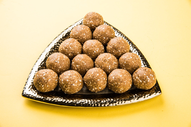 El sésamo indio dulce o tilgul laddu o til gul laddu, compuesto de jaggery y semillas de sésamo, hecho a mano, redondo, dulce indio preparado en el festival Makar Sankranti
 - Foto, imagen