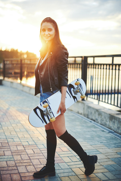 Girl walks in the park to skateboard - Fotoğraf, Görsel
