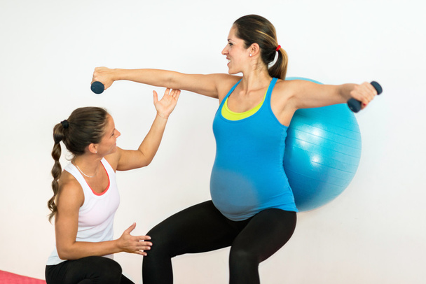 Istruttore di fitness che lavora con una donna incinta
 - Foto, immagini