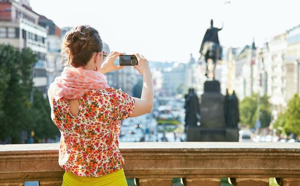 Seen from behind woman taking photos with camera in Prague - Φωτογραφία, εικόνα