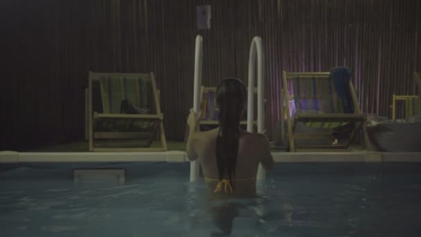 Yüzme havuzundan giderken el raylar tutan seksi genç kadın. - Video, Çekim
