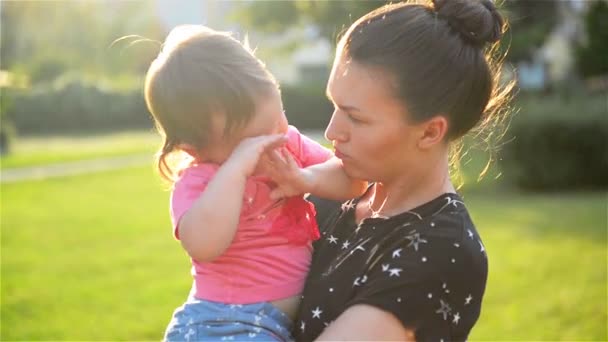 junge schöne Mutter umarmt und tröstet ihre kleine Tochter, Mutter umarmt Baby, Frau beruhigt Mädchen - Filmmaterial, Video