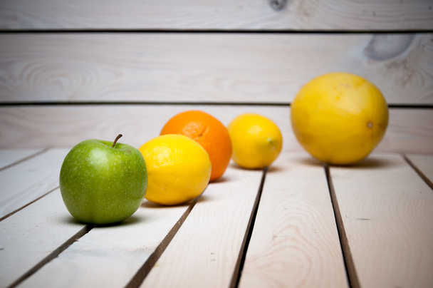 Frutas en línea sobre mesa de madera blanca
 - Foto, imagen