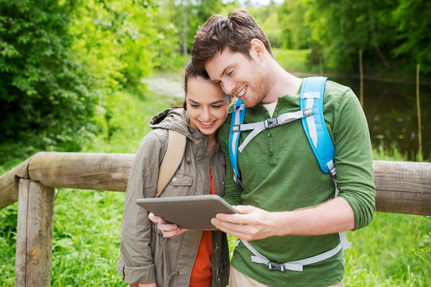 happy couple with backpacks and tablet pc  - Foto, imagen