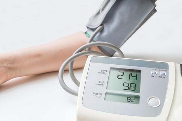 Пацієнт страждає від гіпертонії. Жінка вимірює кров'яний тиск за допомогою цифрового монітора
. - Фото, зображення