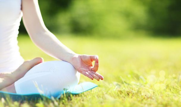 Hand einer meditierenden Frau in Lotusposition, die Yoga praktiziert - Foto, Bild